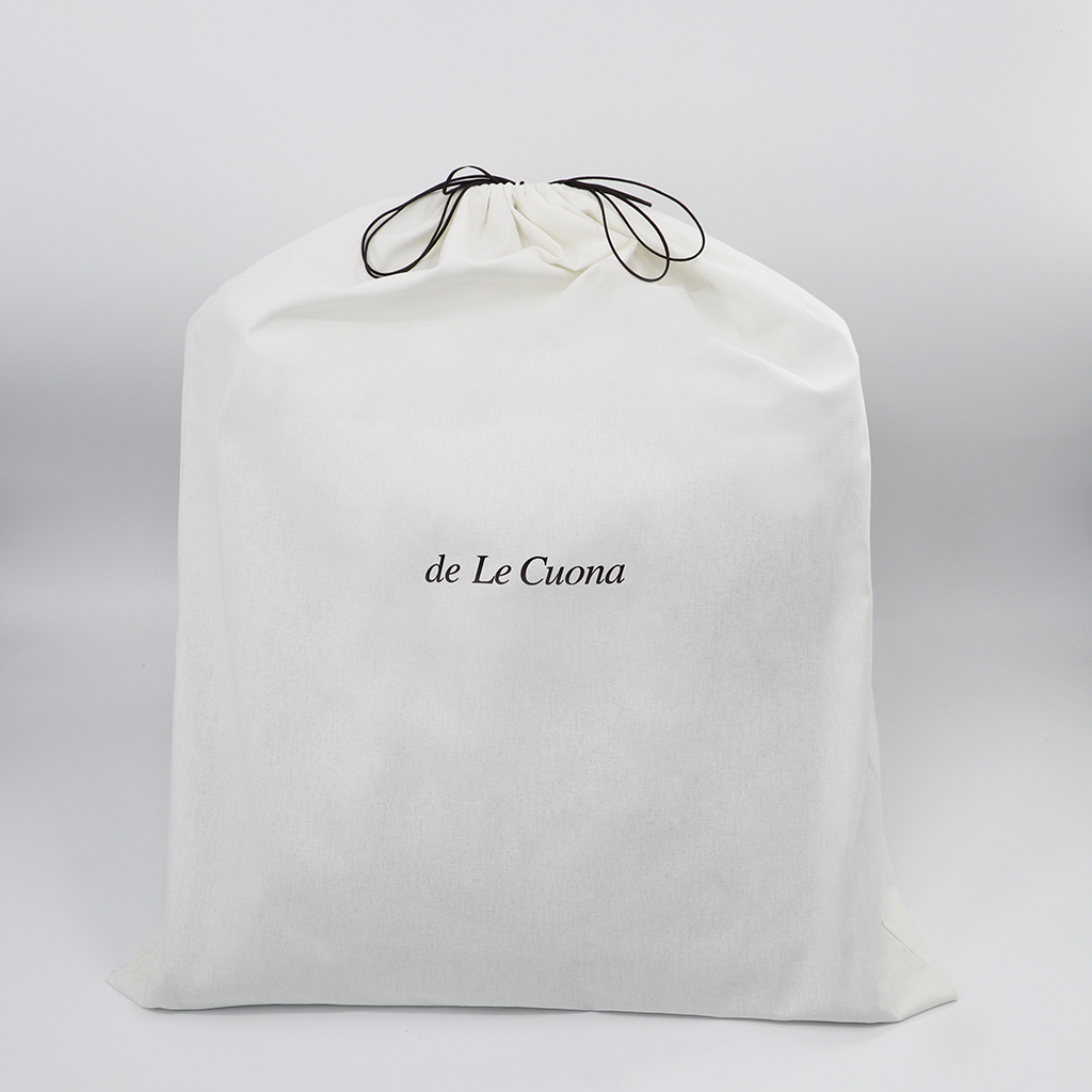 White drawstring bag with 'de Le Cuona' branding on a light gray background