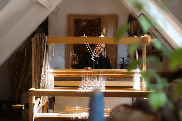 Nancy Nicholson weaving in her studio on a large hand loom