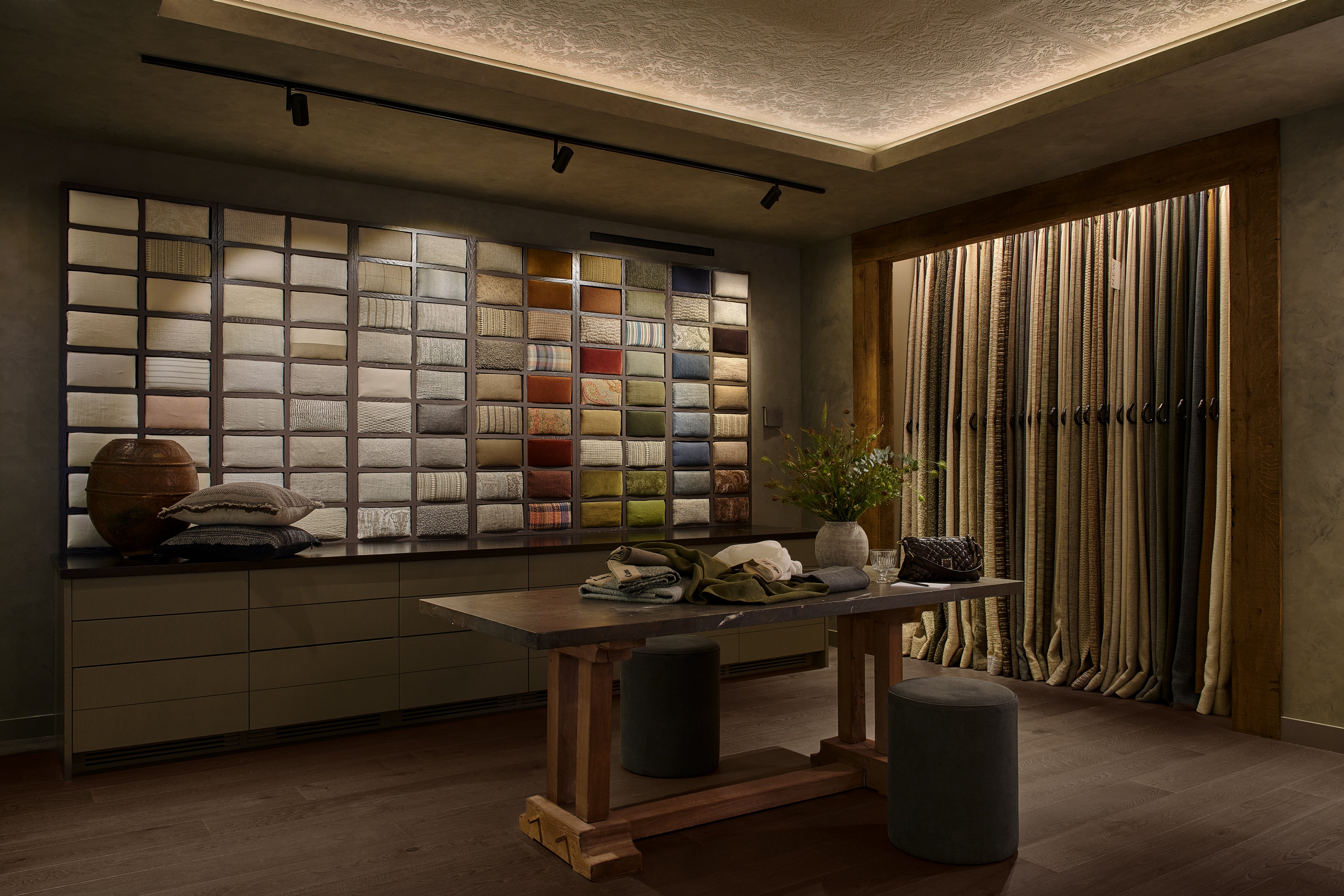 Room with a wall of color swatches and a table with decor items.