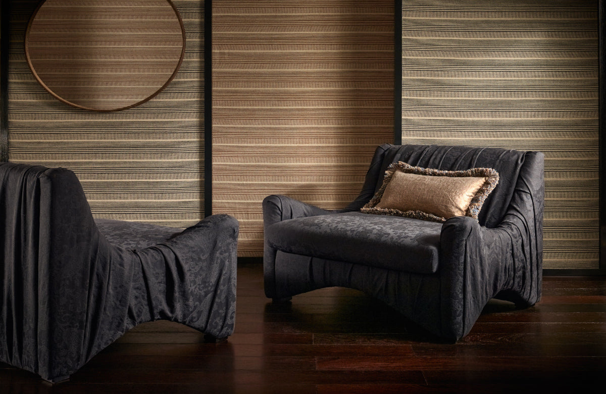 Dark blue armchair with a pillow against a wooden paneled wall.