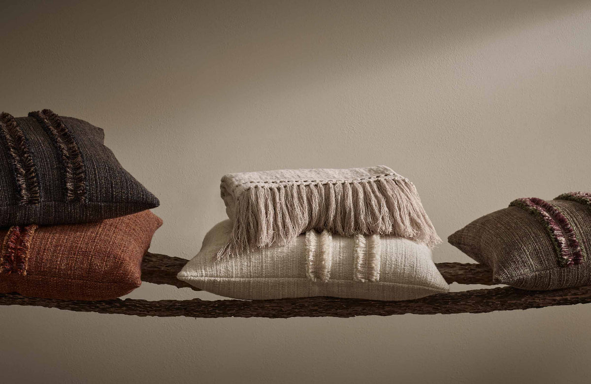 Set of textured pillows with fringe on a neutral background